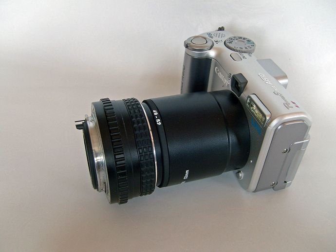 Compactcamera met adaptertubus, omkeerring en omgekeerd 50 mm objectie van een oude spiegelreflexcamera